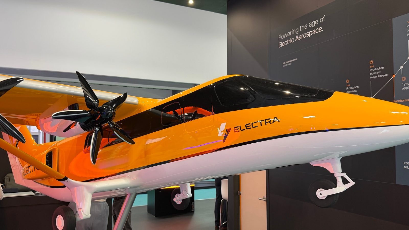 The Electra EL9 hybrid-electric eSTOL aircraft on display at the Electra chalet on the closing day of Farnborough International Airshow 2026, in front of the 'Powering the age of Electric Aerospace' program-milestones wall.